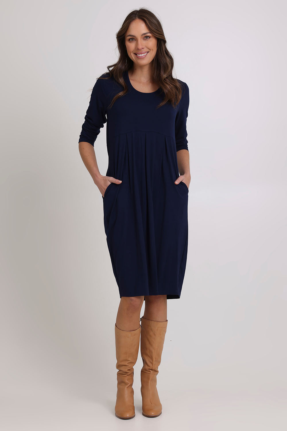 Model Madeline wearing size 10 of the Box Pleat Dress in colour Navy (Blue), from the front, showing the whole outfit