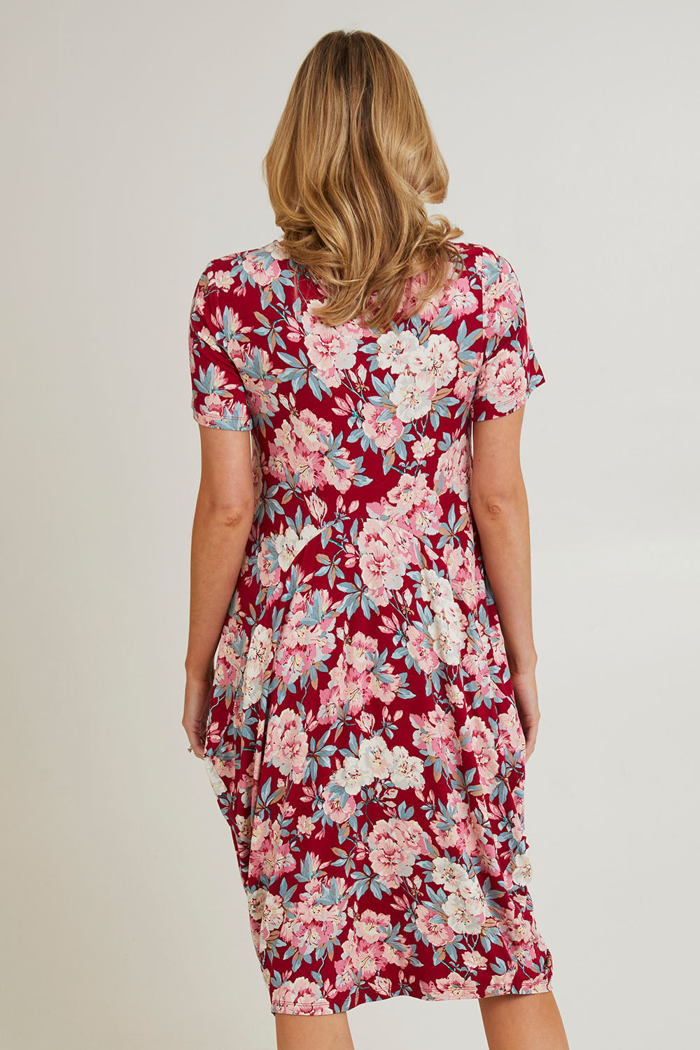 Model Grace wearing size 10 of the Cap Sleeve Bounce Dress in colour Cherry (Red), from the back
