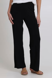 Model Madeline wearing size 10 of the Classic Travel Pant in colour Black (Black), from the front, cropped image