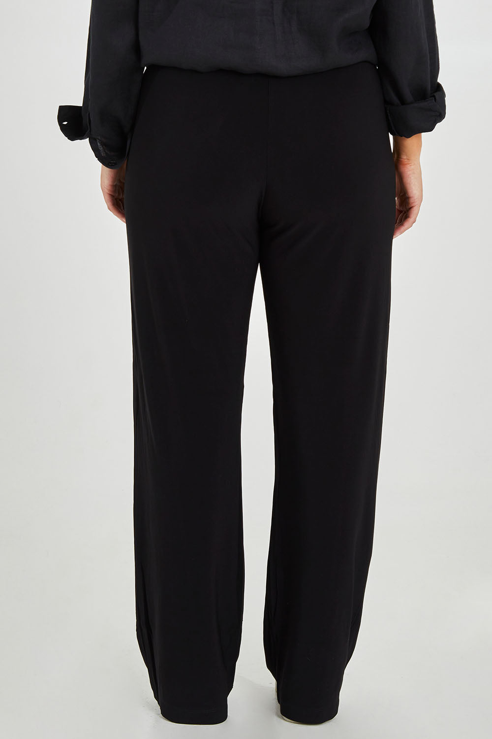 Model Monique wearing size 14 of the Classic Travel Pant in colour Black (Black), from the back
