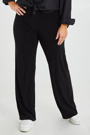 Model Monique wearing size 14 of the Classic Travel Pant in colour Black (Black), from the front, cropped image