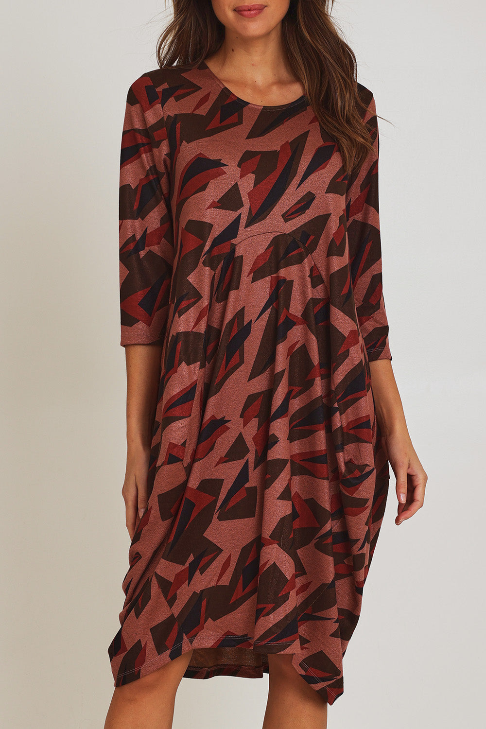 Model Madeline wearing size 10 of the Bounce Dress in colour Pinkred (Pink), from the front, cropped image
