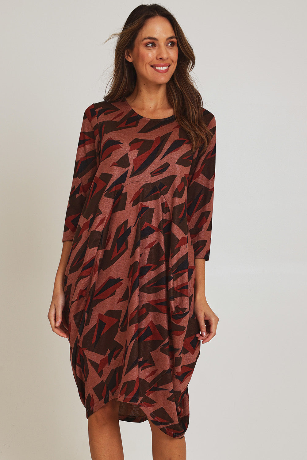 Model Madeline wearing size 10 of the Bounce Dress in colour Pinkred (Pink), from the front, cropped image