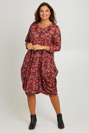 Model Monique wearing size 14 of the Bounce Dress in colour Red (Red), from the front, showing the whole outfit