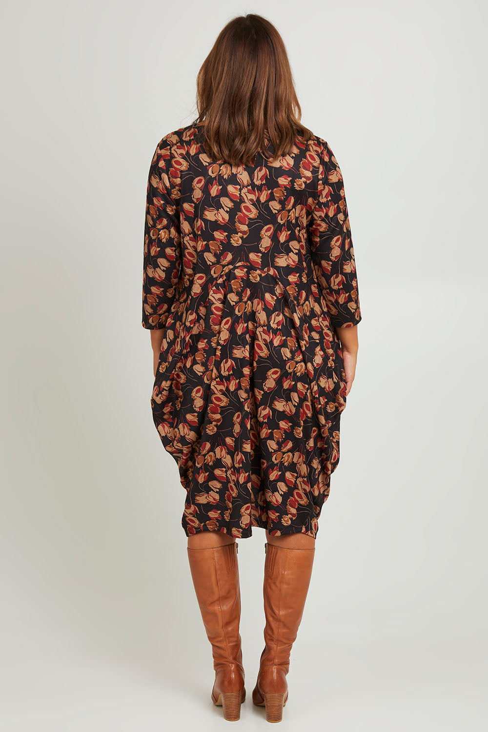 Model Monique wearing size 14 of the Bounce Dress in colour Rust (Black), from the back