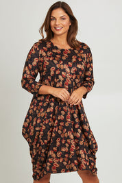 Model Monique wearing size 14 of the Bounce Dress in colour Rust (Black), from the front, cropped image