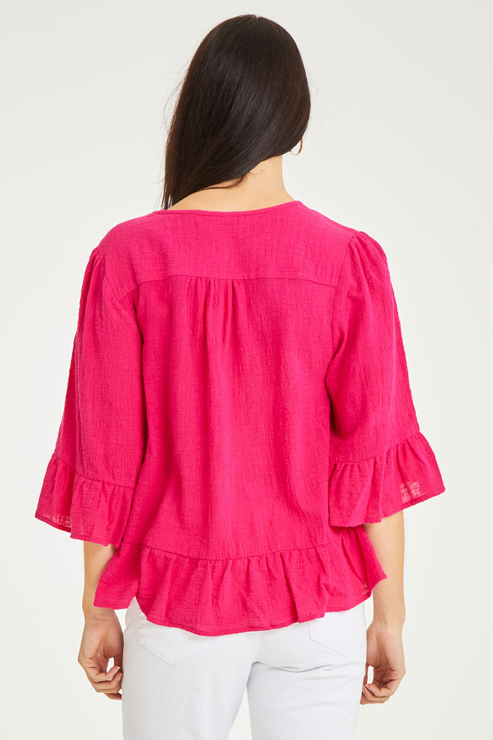 Model Stacey wearing size 10 of the Ruffle Top in colour Hotpink (Pink), from the back