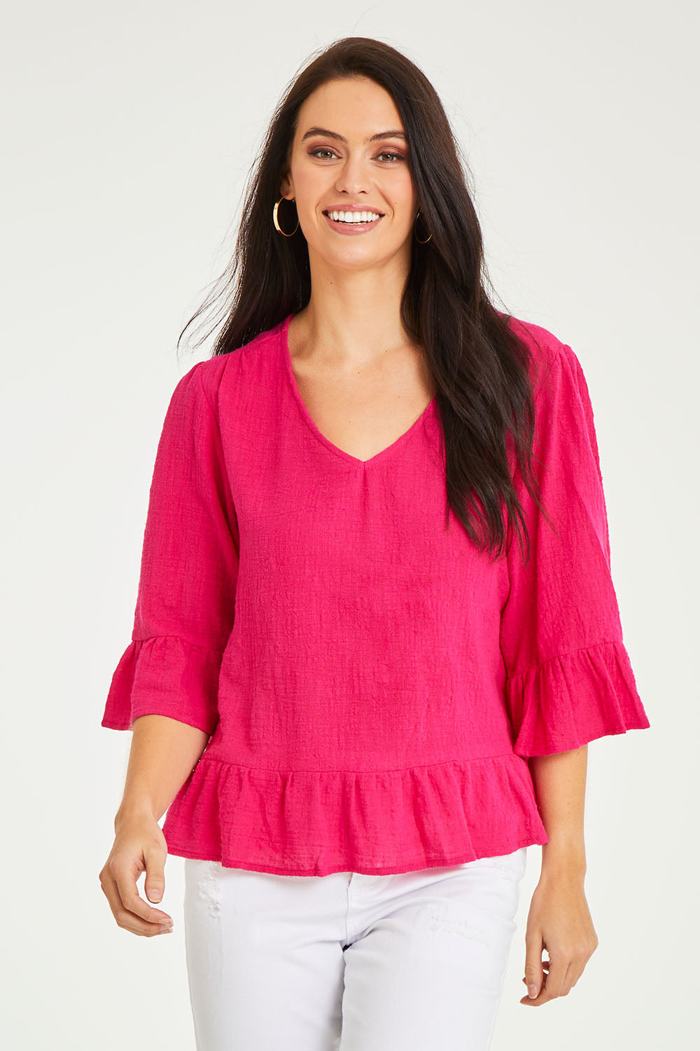 Model Stacey wearing size 10 of the Ruffle Top in colour Hotpink (Pink), from the front, cropped image