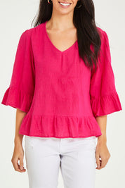 Model Stacey wearing size 10 of the Ruffle Top in colour Hotpink (Pink), from the front, cropped image
