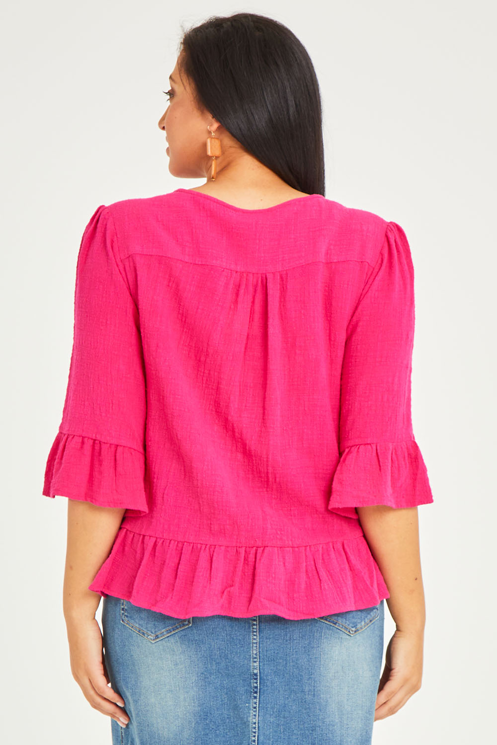 Model Terri-Leigh wearing size 14 of the Ruffle Top in colour Hotpink (Pink), from the back