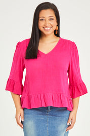 Model Terri-Leigh wearing size 14 of the Ruffle Top in colour Hotpink (Pink), from the front, cropped image