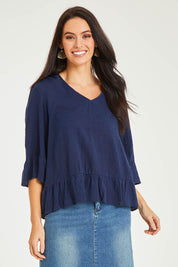 Model Stacey wearing size 10 of the Ruffle Top in colour Navy (Blue), from the front, cropped image
