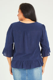Model Terri-Leigh wearing size 14 of the Ruffle Top in colour Navy (Blue), from the back
