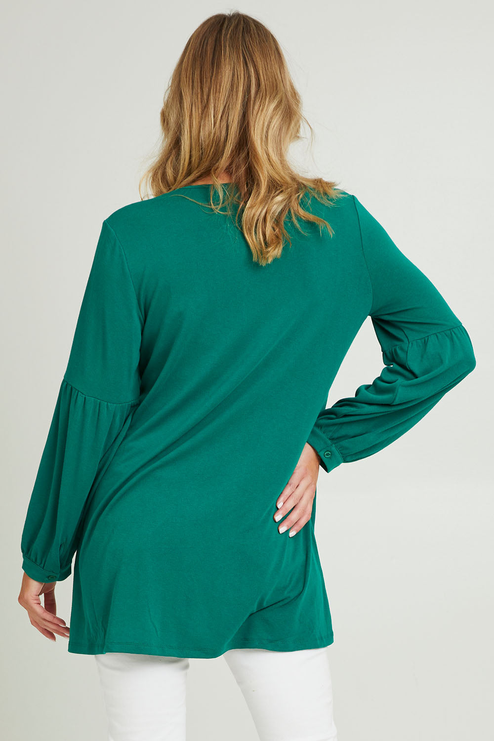 Model Grace wearing size 10 of the Hi Lo Knit Tunic in colour Forest (Green), from the back