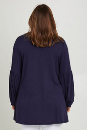Model Monique wearing size 10 of the Hi Lo Knit Tunic in colour Navy (Blue), from the back