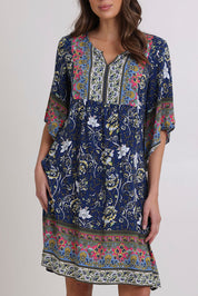 Model Madeline wearing size 10 of the Sun Dress in colour Navyfloral (Blue), from the front, cropped image