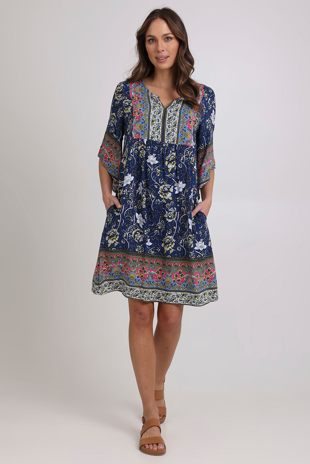 Model Madeline wearing size 10 of the Sun Dress in colour Navyfloral (Blue), from the front, showing the whole outfit