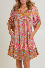 Model Grace wearing size 10 of the Sun Dress in colour Floral, from the front, cropped image