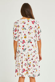 Model Elhana wearing size 10 of the Paradise Print Tunic Dress in colour Print (White), from the back