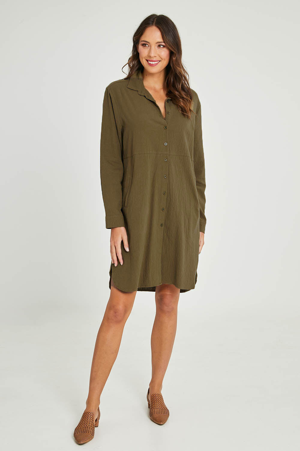 Model Madeline wearing size 10 of the Splice Print Tunic Shirt in colour Khaki (Green), from the front, showing the whole outfit