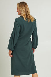 Model Grace wearing size 10 of the Upcycle Midi Shirt Dress in colour Forest (Green), from the back