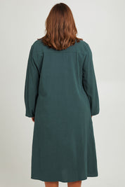 Model Monique wearing size 14 of the Upcycle Midi Shirt Dress in colour Forest (Green), from the back
