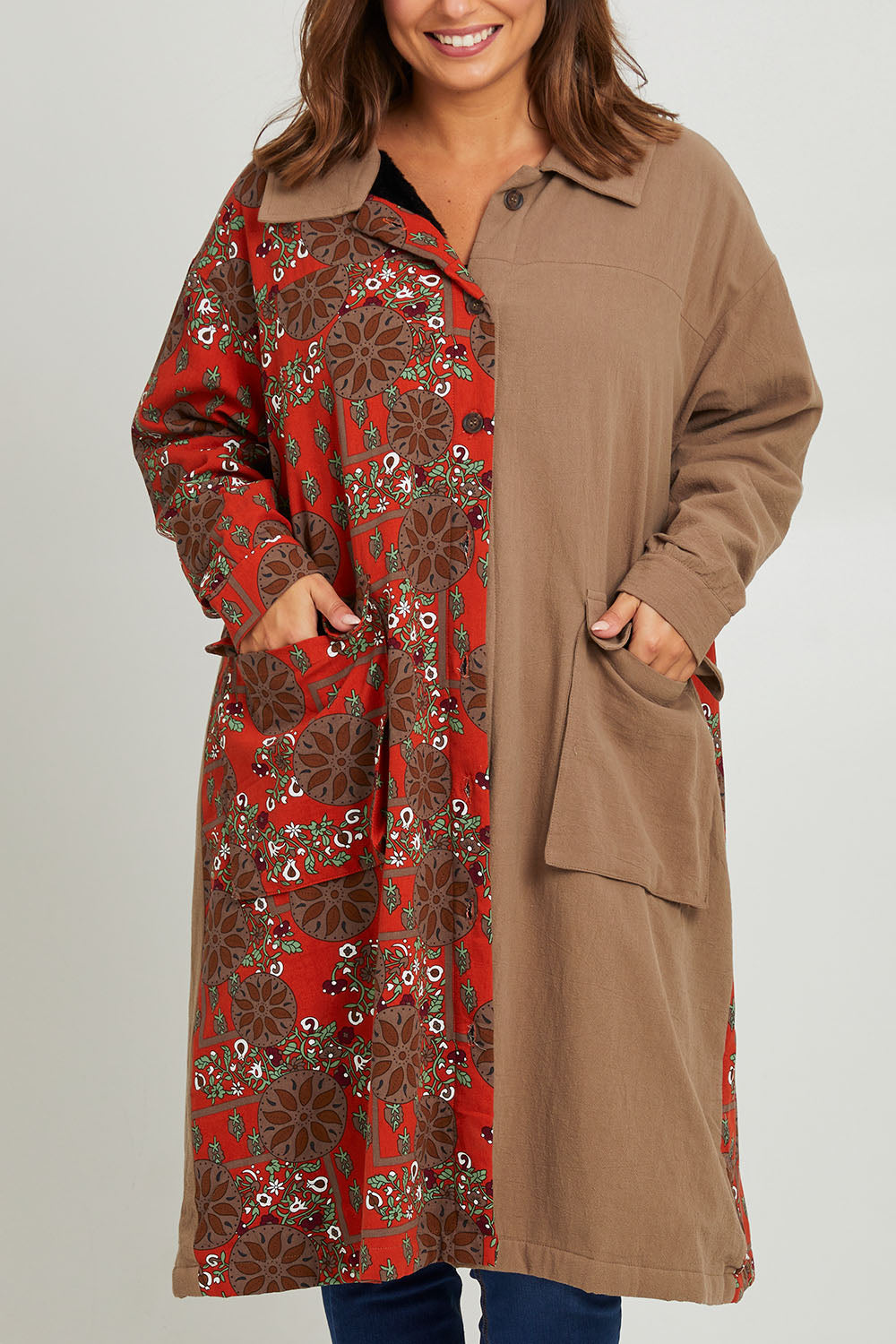 Model Monique wearing size 14 of the Print Splice Coat in colour Rust (Red), from the front, cropped image