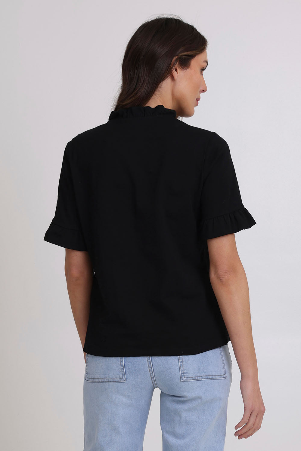 Model Madeline wearing size 10 of the Ruffle Tee Top in colour Black (Black), from the back