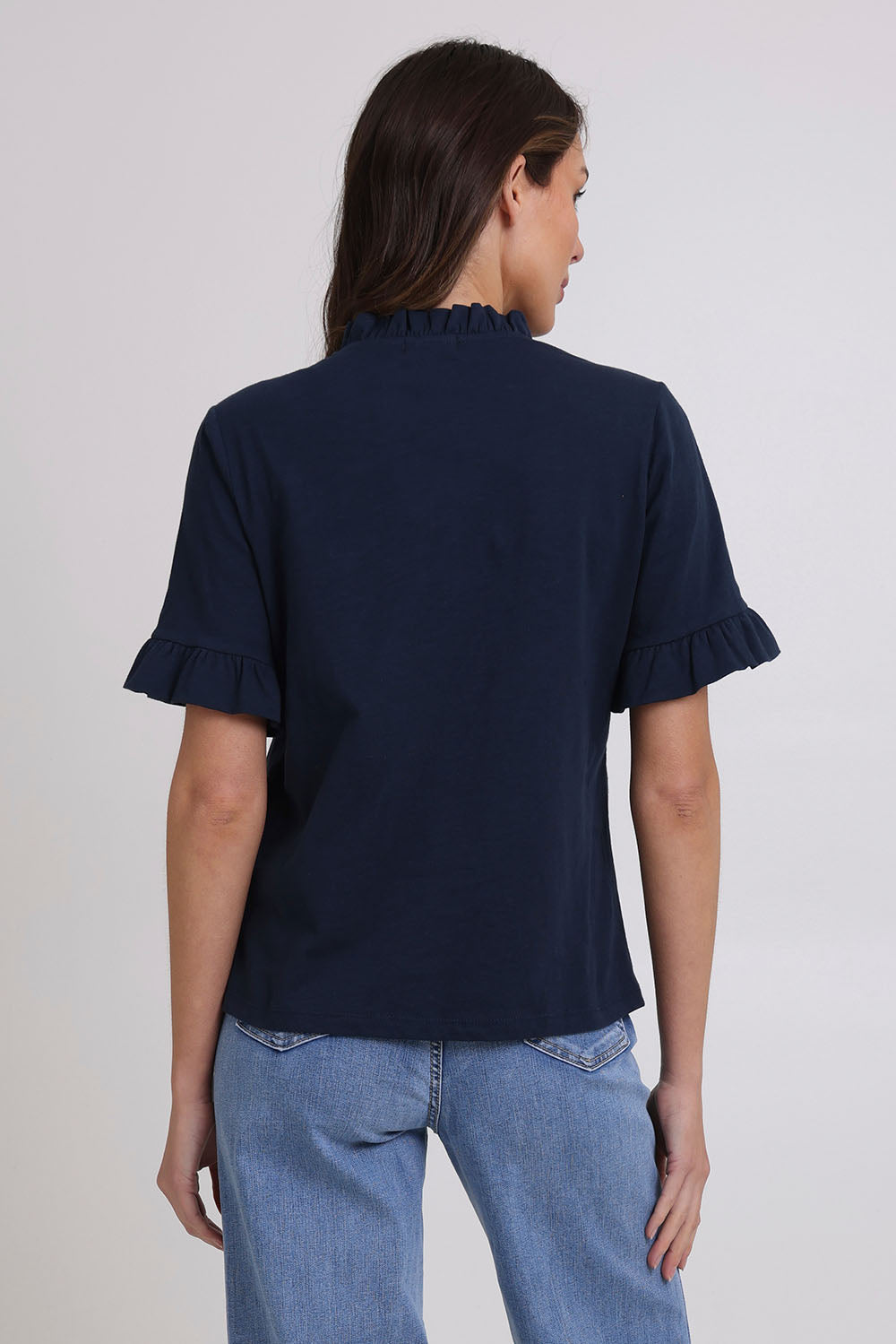 Model Madeline wearing size 10 of the Ruffle Tee Top in colour Navy (Blue), from the back