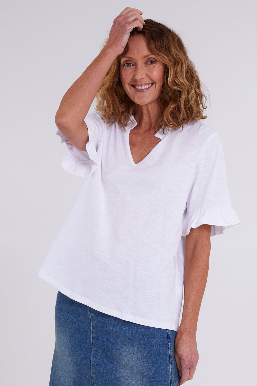 Model Emma wearing size 10 of the Ruffle Tee Top in colour White (White), from the front, cropped image