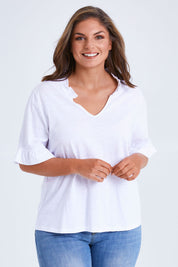 Model Monique wearing size 14 of the Ruffle Tee Top in colour White (White), from the front, cropped image