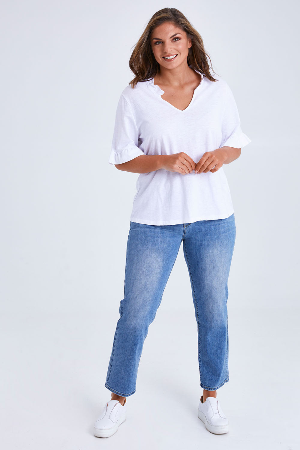 Model Monique wearing size 14 of the Ruffle Tee Top in colour White (White), from the front, showing the whole outfit