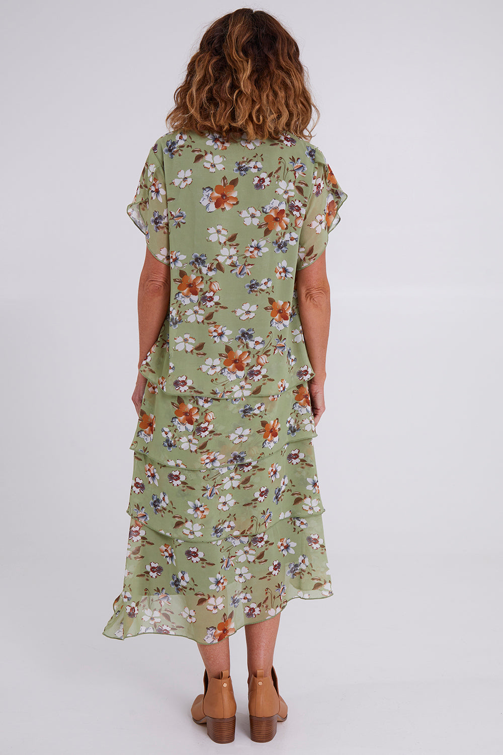 Model Emma wearing size 10 of the Floral Tiers Print Dress in colour Sage (Green), from the back