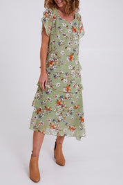Model Emma wearing size 10 of the Floral Tiers Print Dress in colour Sage (Green), from the front, cropped image