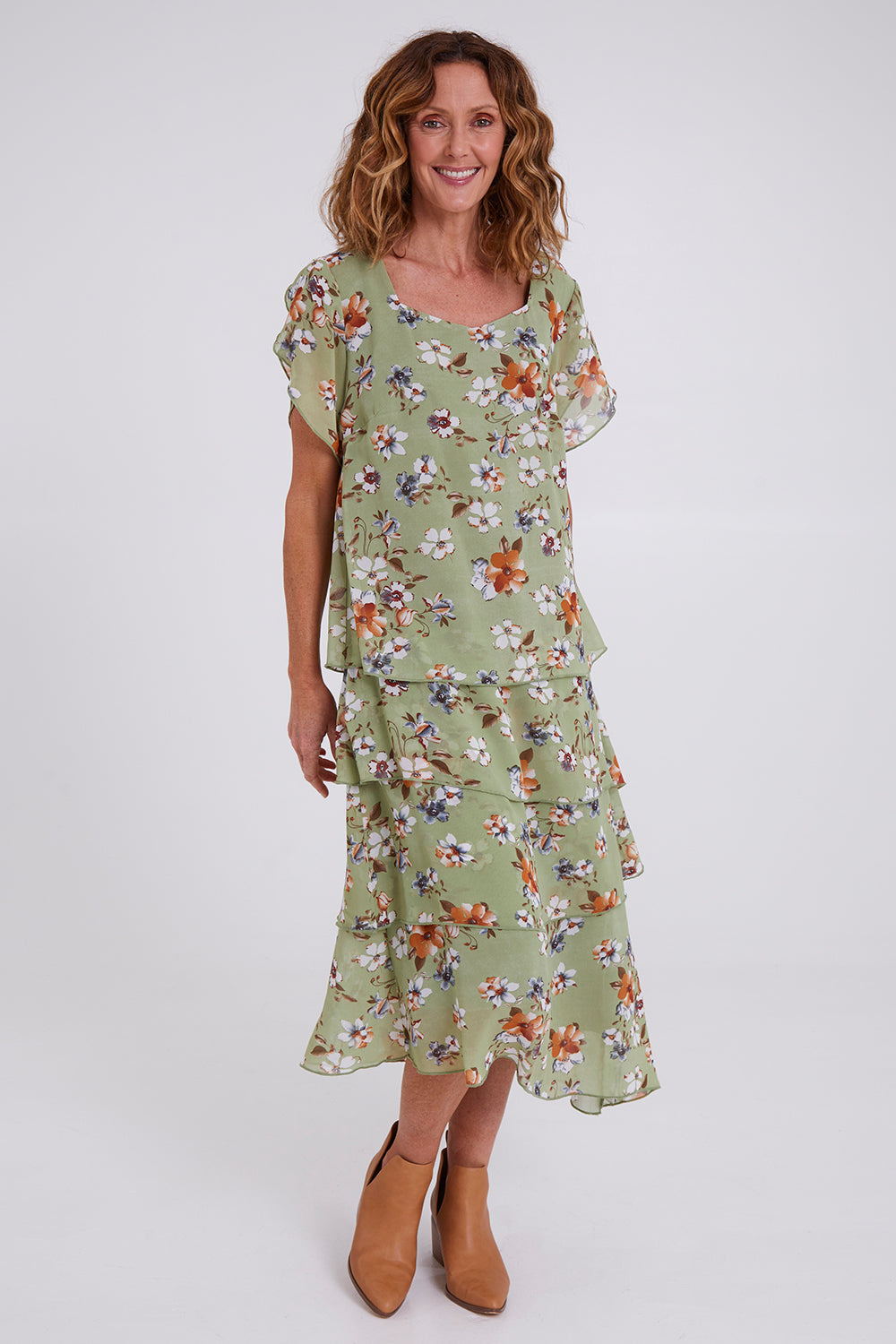 Model Emma wearing size 10 of the Floral Tiers Print Dress in colour Sage (Green), from the front, showing the whole outfit