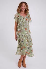 Model Emma wearing size 10 of the Floral Tiers Print Dress in colour Sage (Green), from the front, showing the whole outfit