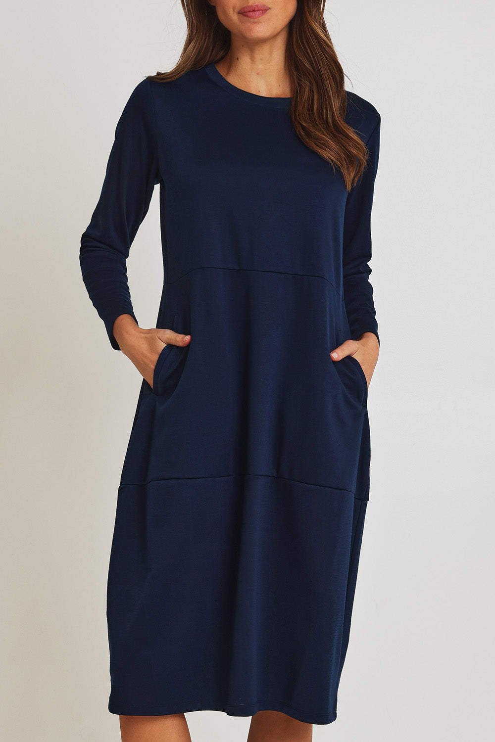 Model Madeline wearing size 10 of the Core Pocket Dress in colour Navy (Blue), from the front, cropped image
