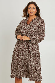 Model Monique wearing size 14 of the Felicia Dress in colour Mocha, from the front, cropped image