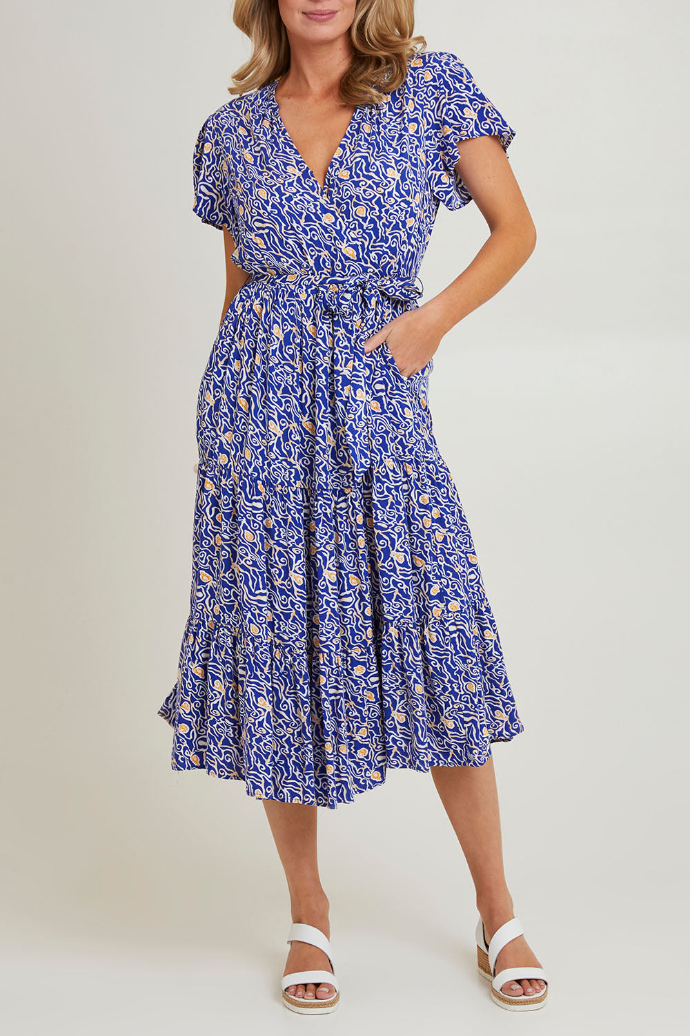 Model Grace wearing size 10 of the Wrap Flutter Dress in colour Royal (Blue), from the front, cropped image