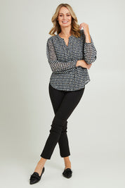 Model Grace wearing size 10 of the Chiffon Pintuck Top in colour Check (Black), from the front, showing the whole outfit