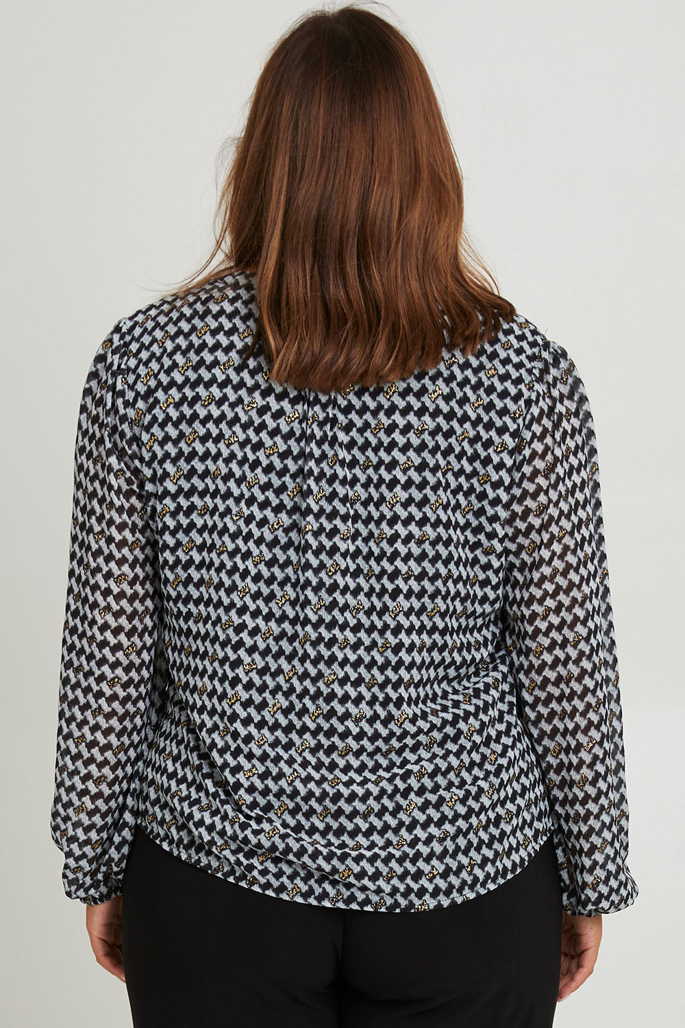 Model Monique wearing size 14 of the Chiffon Pintuck Top in colour Check (Black), from the back