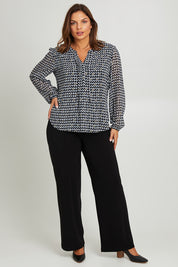 Model Monique wearing size 14 of the Chiffon Pintuck Top in colour Check (Black), from the front, showing the whole outfit