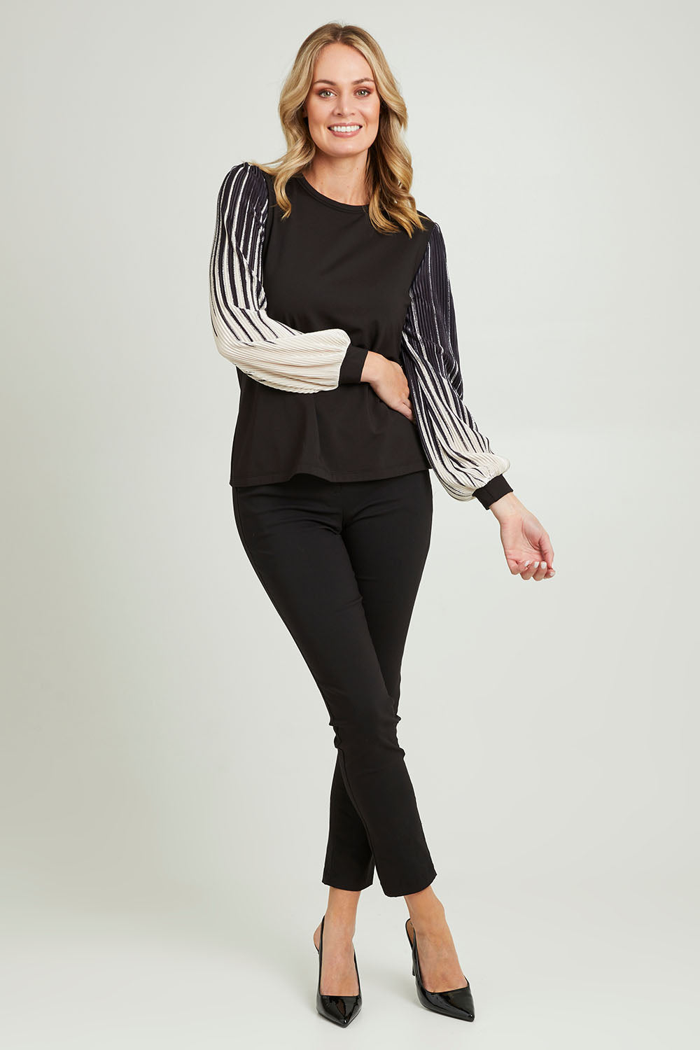 Model Grace wearing size 10 of the Contrast Pleat Top in colour Black (Black), from the front, showing the whole outfit