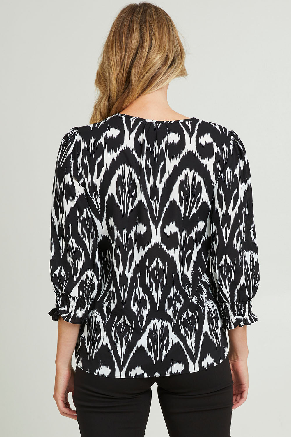 Model Grace wearing size 10 of the Felicia Top in colour Aztec (Blue), from the back