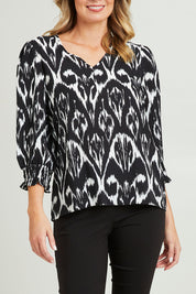 Model Grace wearing size 10 of the Felicia Top in colour Aztec (Blue), from the front, cropped image