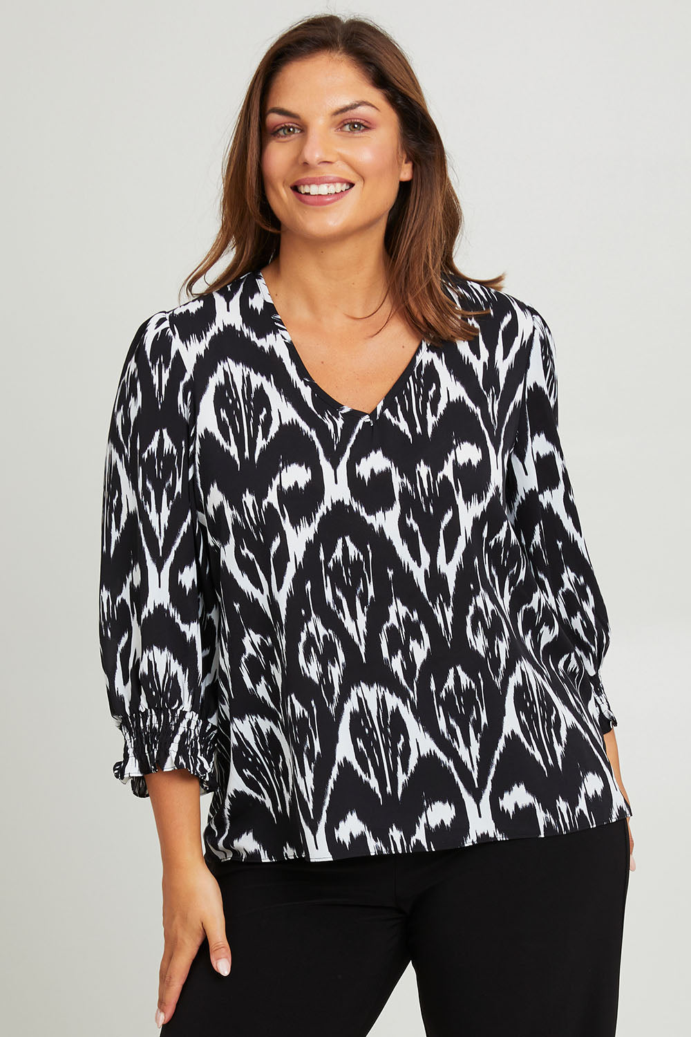 Model Monique wearing size 14 of the Felicia Top in colour Aztec (Blue), from the front, cropped image
