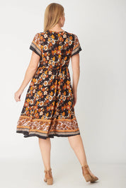 A model wearing The Flounce Dress in colour Black (Black), from the back