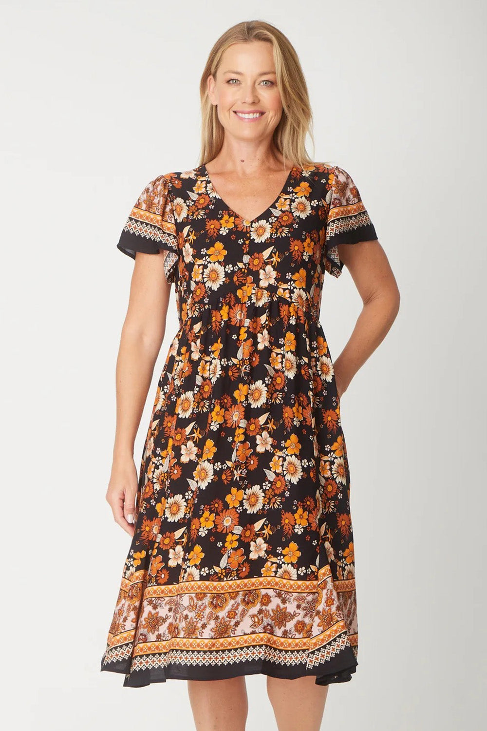 A model wearing The Flounce Dress in colour Black (Black), from the front, cropped image