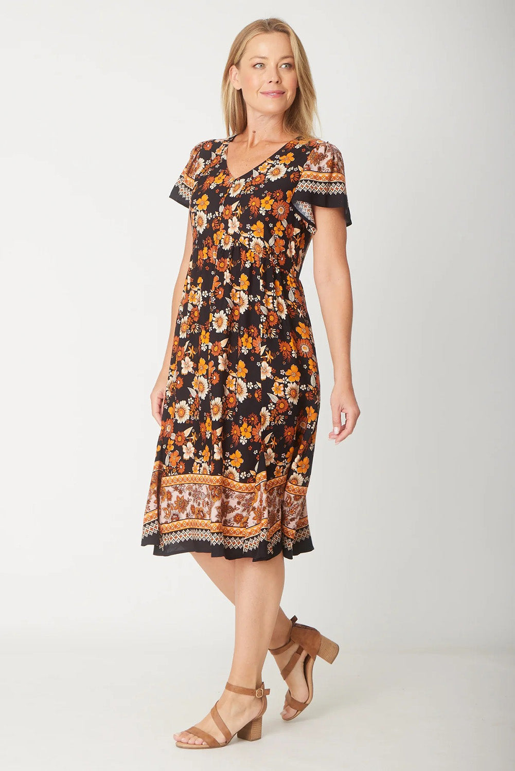 A model wearing The Flounce Dress in colour Black (Black), from the front, showing the whole outfit