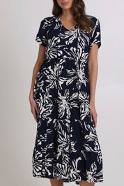 Model Madeline wearing size 10 of the Tier Garden Dress in colour Navy (Blue), from the front, cropped image